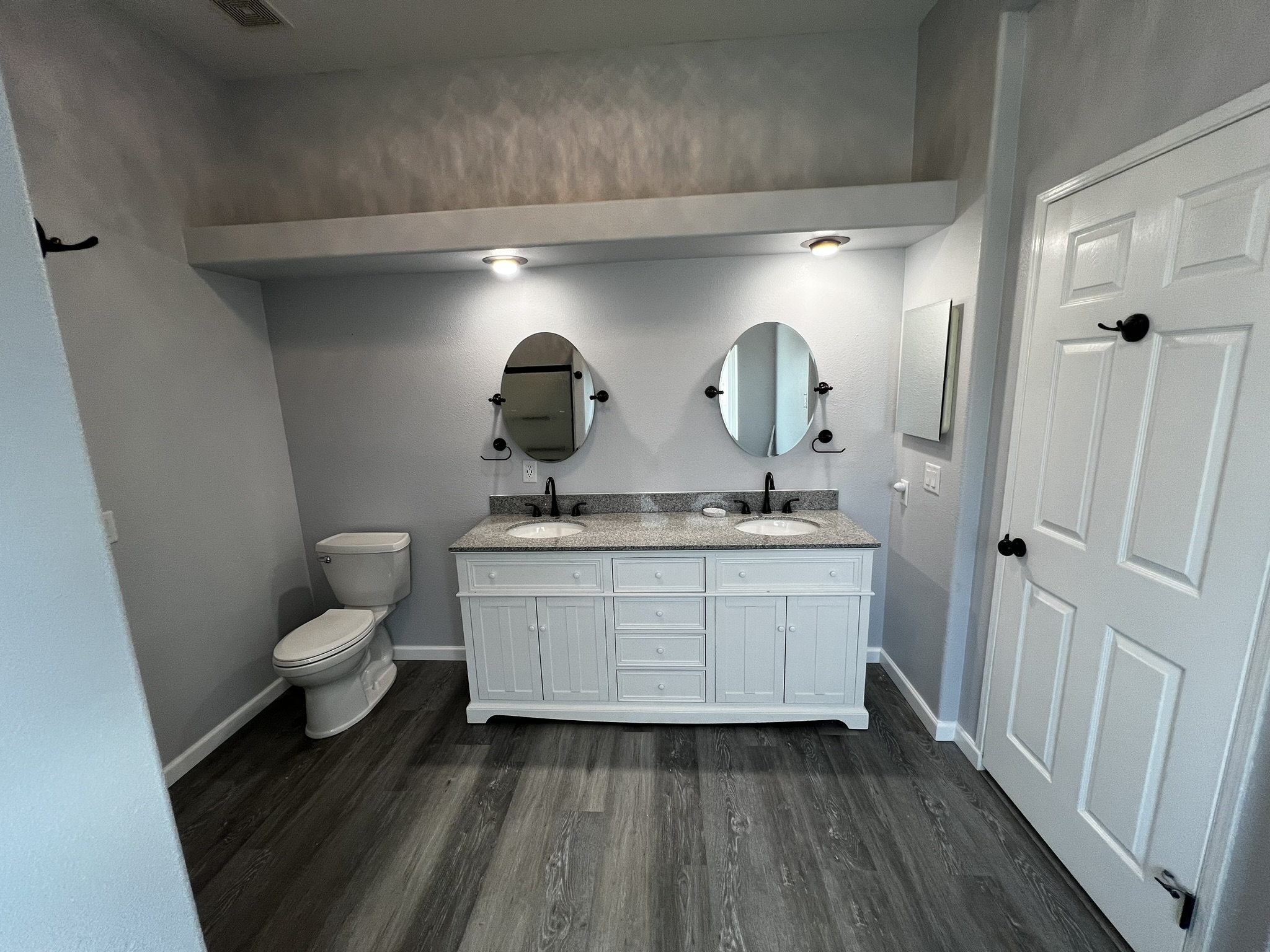 A finished full master bathroom remodel with blue vanity and tile